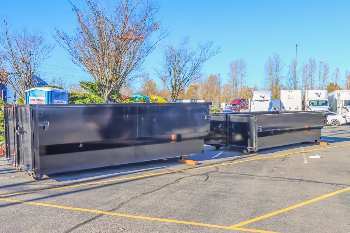 Professional dumpster rental service with roll-off container on residential driveway in East End